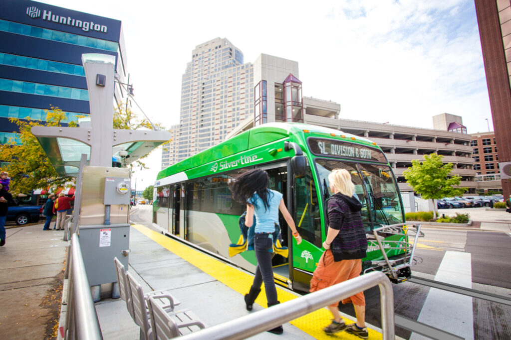 A green bus is parked at the platform.
